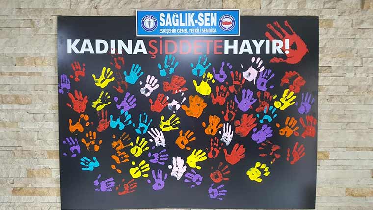 Sağlık Sen Eskişehir Şubesi Kadınlar Komisyonu üyeleri, Eskişehir Devlet Hastanesi Poliklinik girişinde hazırladıkları “Kadına Şiddete Hayır” panosuna boyalı ellerini kapıştırarak 'kadına şiddete hayır' işaretini oluşturdular.